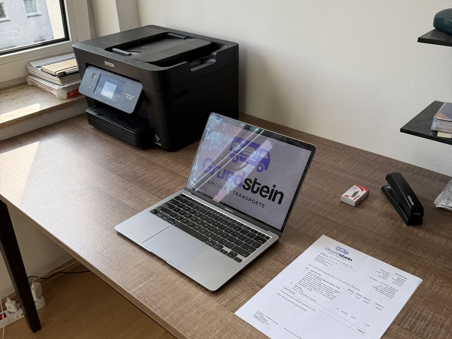 Bueroarbeitsplatz mit Drucker und Laptop vor dem Firmenumzug